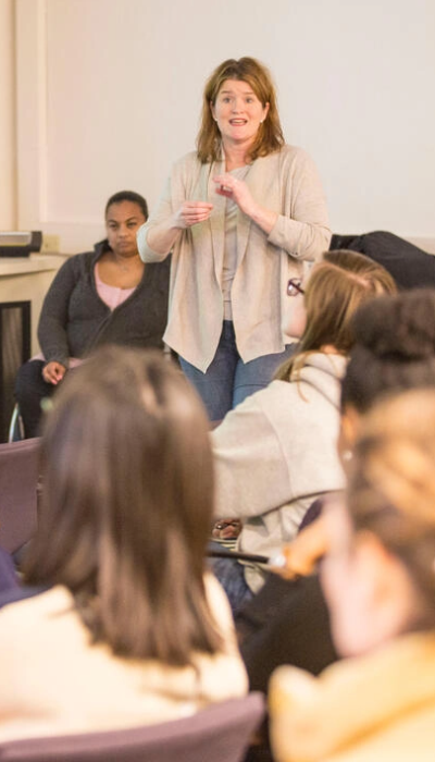 A woman giving a presentation to a group of people.