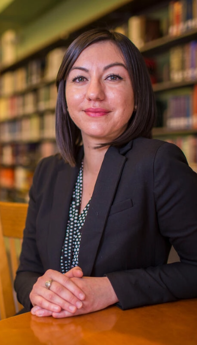 A woman sitting at a table in a library.