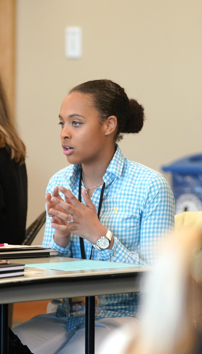 Two women sitting at a table talking to each other.