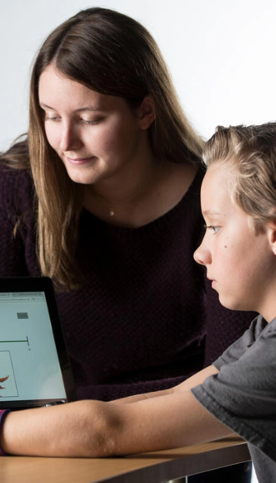 A woman and a boy looking at a tablet computer.