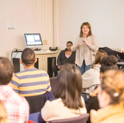 A woman giving a presentation to a group of people.