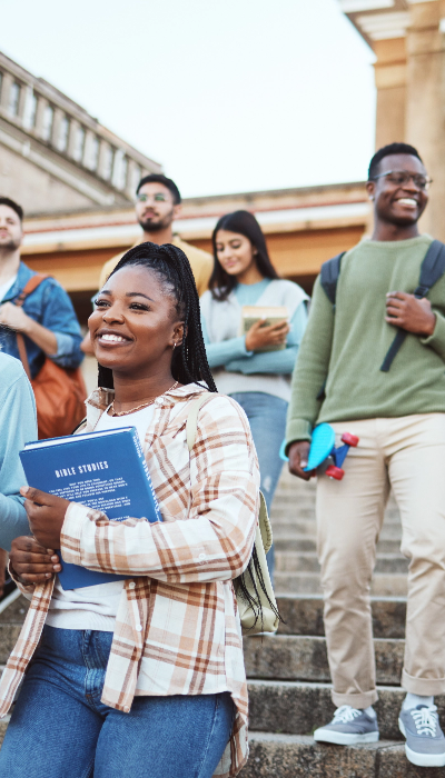 A group of students standing on the steps of a building.