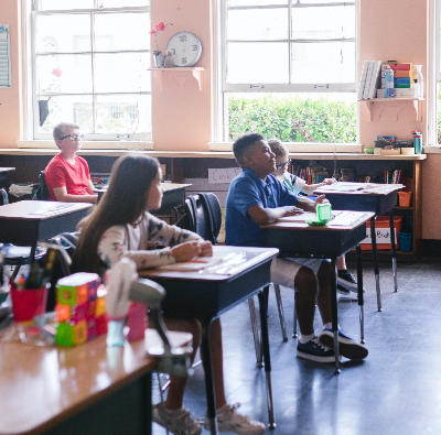 A group of children sitting at desks in a classroom.