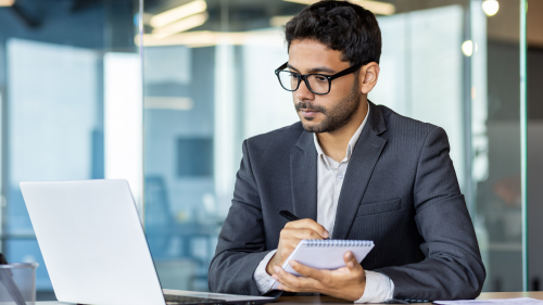 A businessman working on a laptop in an office.