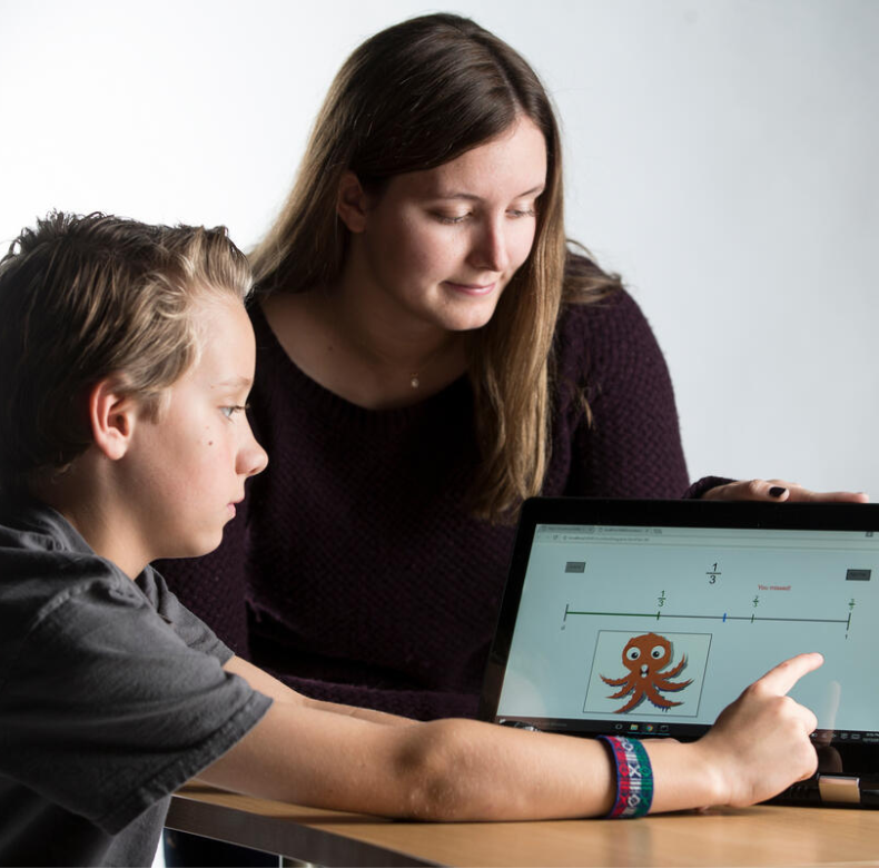 A woman and a boy looking at an octopus on a laptop.