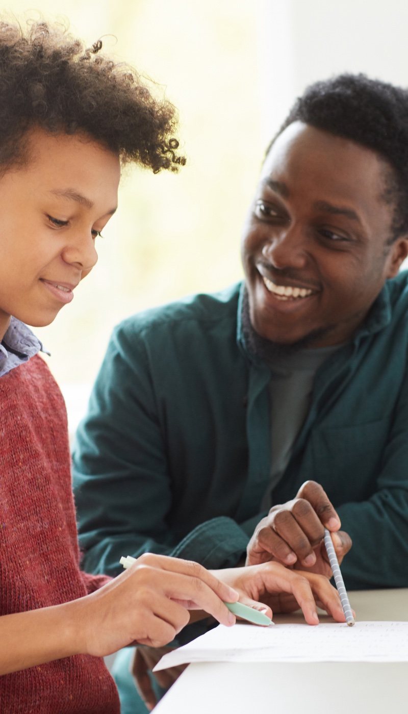 A teacher and a student working together on a piece of paper.