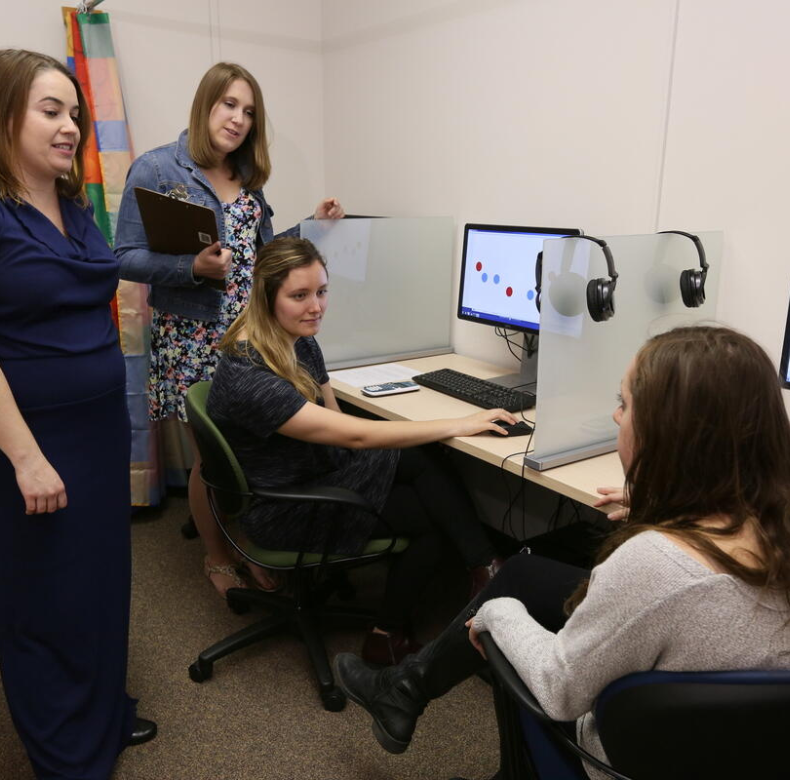 A group of women sitting around a desk.